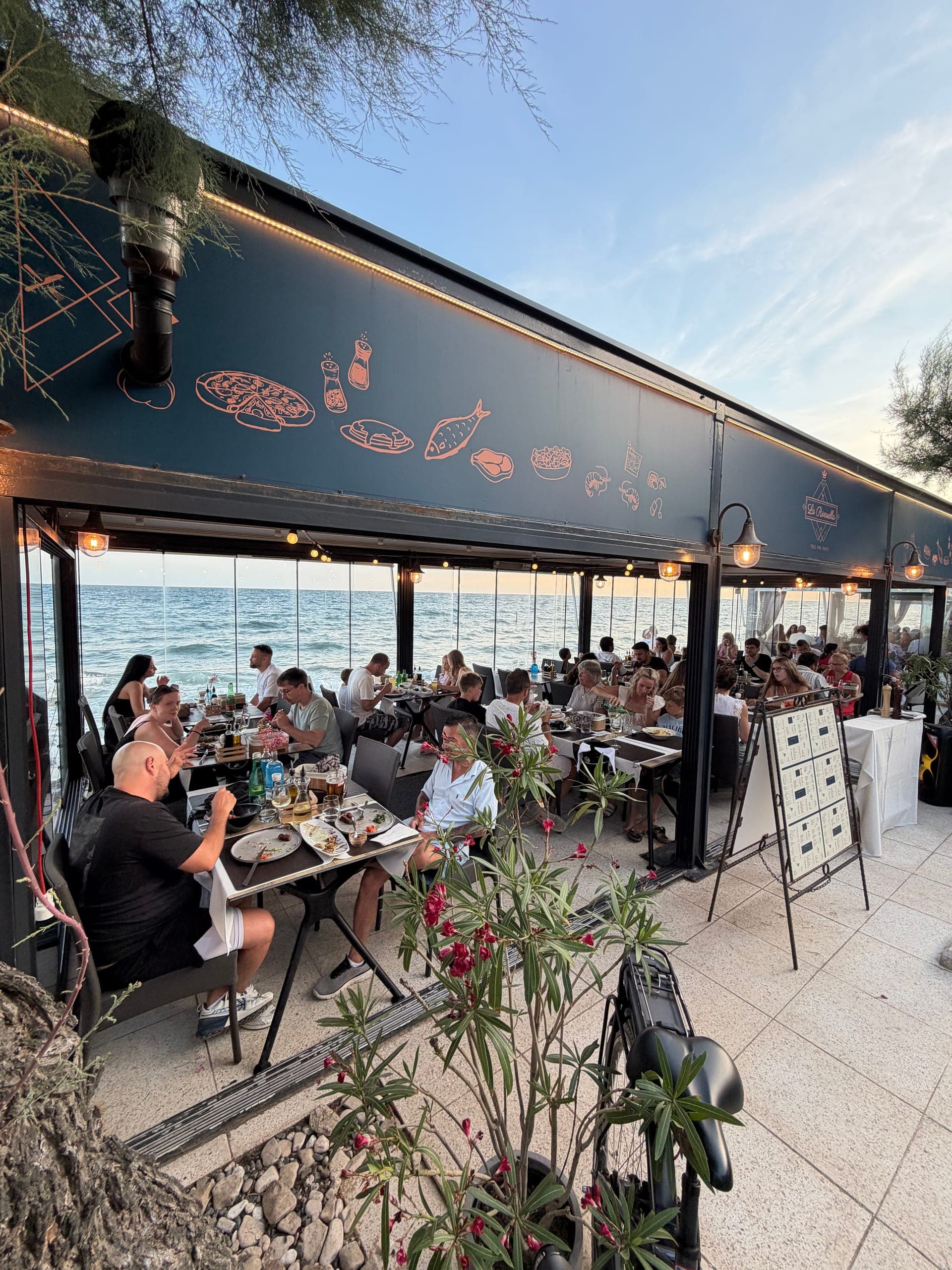 Terasa restorana La Rivarella uz samo more sa suncobranima